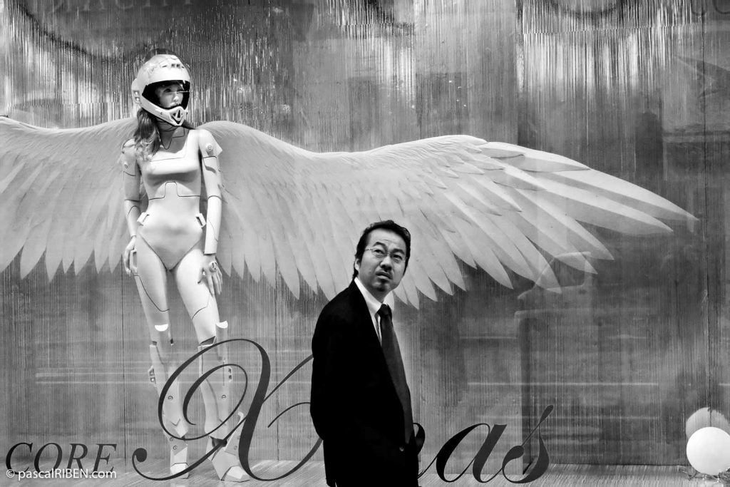 A Japanese man walk in front of a shop showcasing a woman angel in Ginza District, Tokyo, Japan