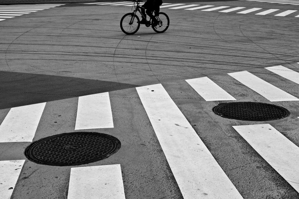 Bicycle wheels and manhole covers at Shibuya Crossing in Tokyo, Japan.