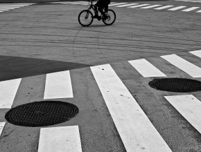 Bicycle wheels and manhole covers with crosswalk in Tokyo, Japan.