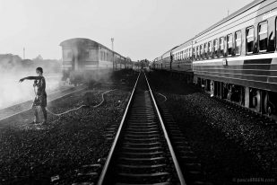 Nong Khai Railway Station - Shower on the Track A man is taking a shower on the tracks at Nong Khai railway station in Thailand.