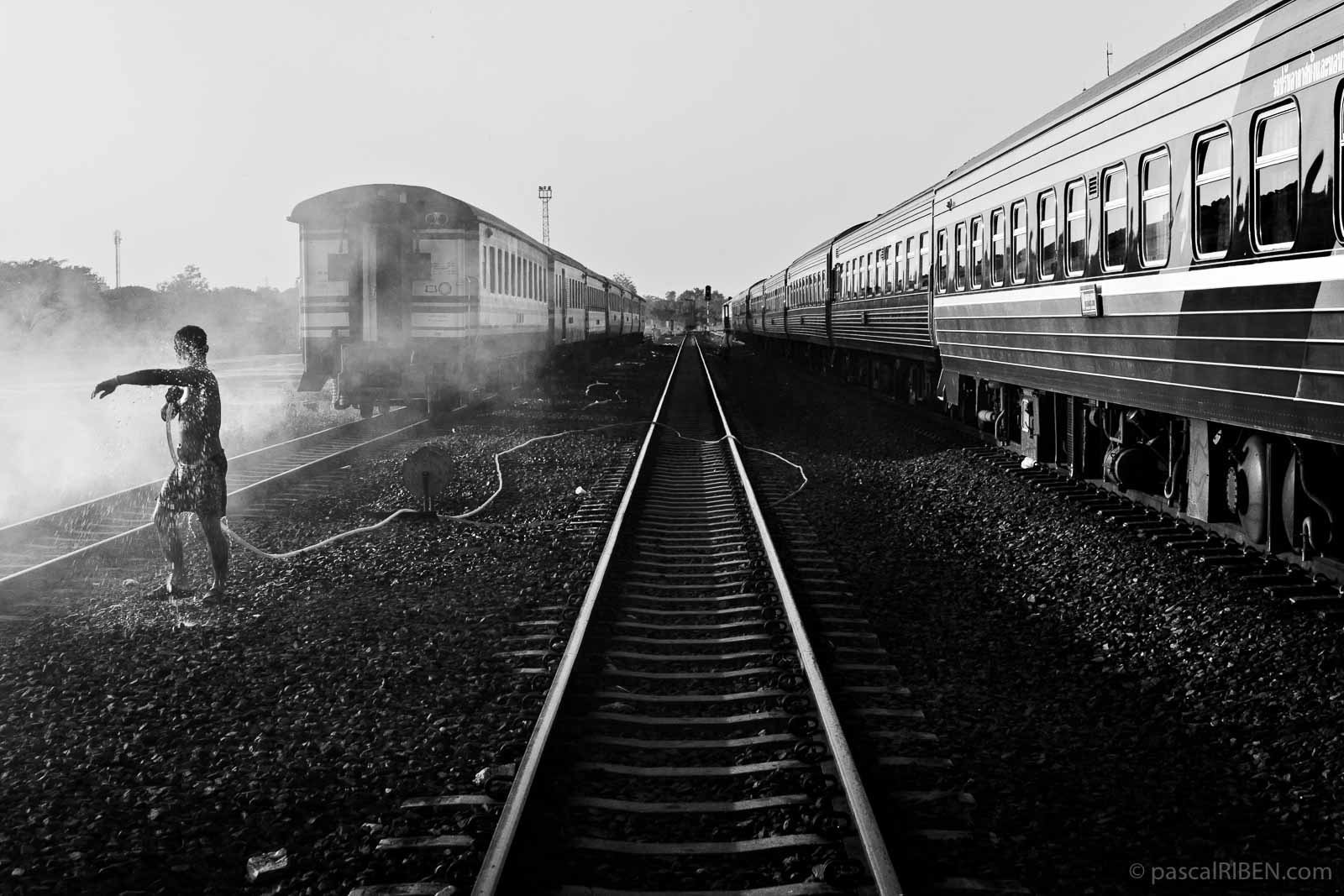 A man is taking a shower on the tracks at Nong Khai railway station in Thailand.