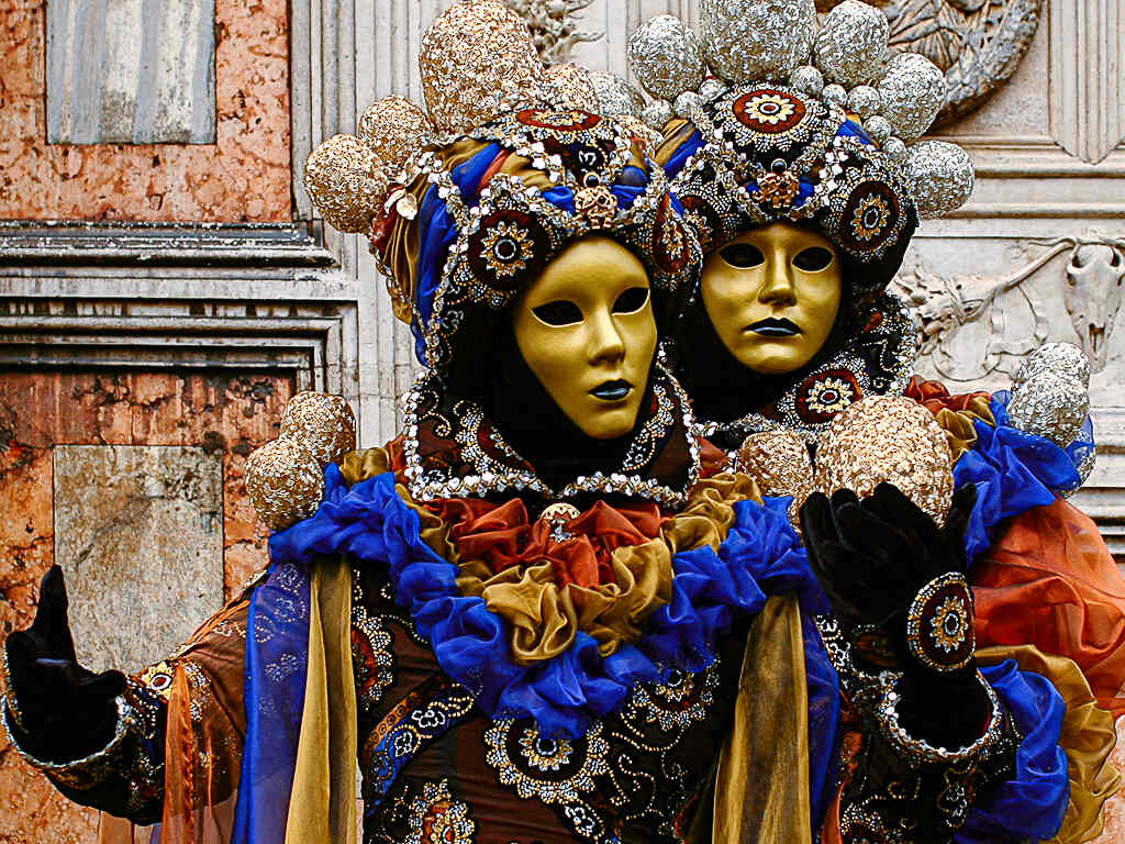 Masked couple in Carnival of Venice shot in front of Chiesa di San Zaccaria